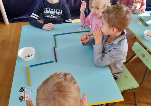 Dzieci siedzą przy stoliku i wykonują kolejne zadanie konkursowe