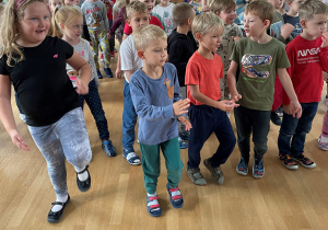 Dzieci tańczące na sali gimnastycznej.