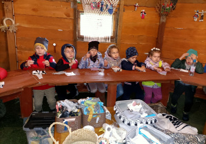 Dzieci przygotowują sznurki do zrobienia motanki.
