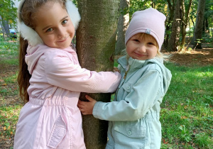 Lisana i Matylda przytulają się do drzewa.