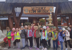 Grupa dzieci na tle wejścia do zoo.