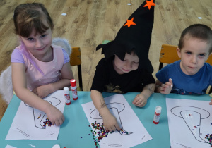 zdjecie 3 - Dzieci wyklejają kapelusz czarodzieja cekinami