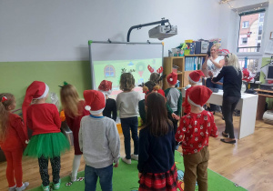 Dzieci tańczą i śpiewają piosenkę o świętym Mikołaju