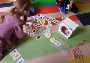 Dzieci poszukują par odpowiednich ubrań w grze logopedycznej „ Pralka z ubraniami”