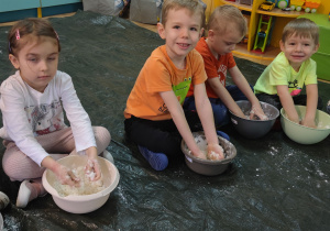 Zdj. 3- Przedszkolaki ugniatają mąkę w miskach