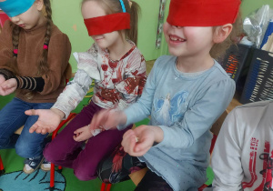 Dzieci z zakrytymi oczami zgadują poprzez dotyk co trzymają w ręce