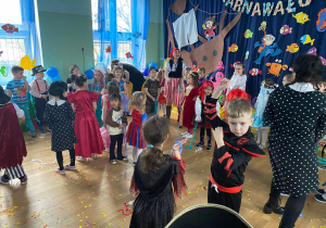 Dzieci w karnawałowych przebraniach tańczą do muzyki