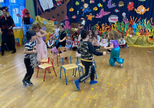 Dzieci uczestniczą w zabawie "znikające krzesełko"