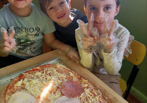 Miłosz, Stefan i Kacper prezentują swoją pizzę.