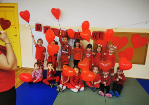 Cała grupa z balonami w kształcie serduszek oraz wszyscy ubrani na czerwono