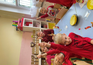 Dzieci pozują do zdjęcia z czekoladowymi lizakami serduszkami