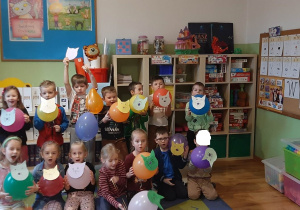 Dzieci trzymają w ręce koty stworzone z balonów.