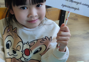 zdjecie 4 - Dziewczynka trzyma tabliczkę z napisem: specjalista zdrowych nawyków żywieniowych