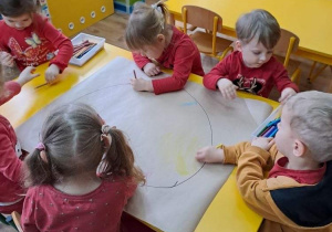 5 dzieci przy stole kolorują serce