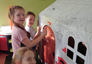 Starsze dziewczynki zaczynają malować trudne elementy – małe cegiełki wokół drzwi i okna.