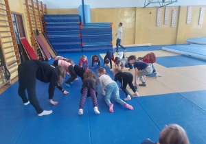 Dzieci rozgrzewają się przed ćwiczeniami z akrobatyki