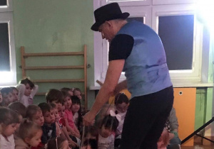4. Aktor sadza dziewczynce marionetkę na kolanach
