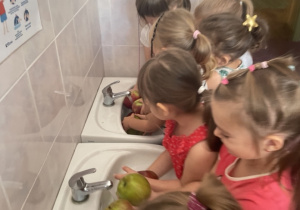 Dzieci myją jabłka.