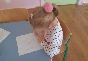 Dziewczynka tworzy obraz z kropek.