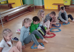 Dzieci doskonalą chwyt kasztanów swoimi stopami.