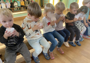 Zdjęcie dzieci pijących „magiczny” sok podczas warsztatów z suchym lodem.