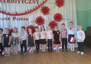Martynka, Hania, Sylwek, Antosia, Zuza i pozostałe dzieci na baczność śpiewają piosenkę.