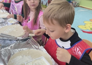 Dzieci smarują serkami śmietankowym placki do tortilli