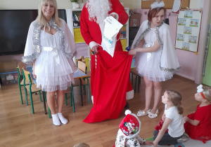 Mikołaj daje dzieciom paczuszkę z prezentami