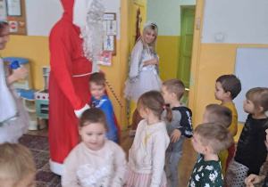 Dzieci przyjmują Mikołaja, śpiewają mu piosenki.