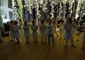 Dzieci tańczą, trzymają w rączkach biało czerwone laski (cukrowe lizaki)