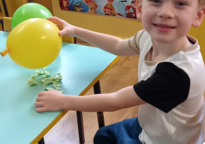 Chłopiec trzyma naelektryzowany balon.
