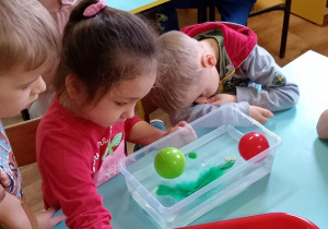 Dzieci sprawdzają, które przedmioty unoszą się na wodzie.