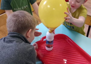 Chłopiec podtrzymuje rosnący balon.