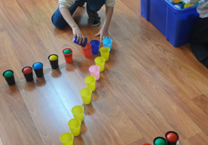Dzieci za pomocą piłeczek układają literkę Z