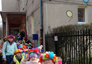 Dzieci z grupy Tygrysków czekają przed budynkiem przedszkola na rozpoczęcie wiosennego korowodu na Stawy Jana.