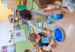 Dzieci nabierają za pomocą pipety niebieski barwnik.