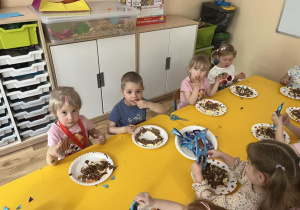 Zdjęcie przedstawiające dzieci podczas degustacji owoców oblanych czekoladą.