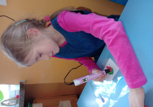 Alicja kończy drukowanie swojego arbuza - sprawdza poziom filamentu w długopisie,