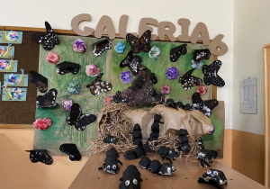 Galeria grupy 6 a w niej majowa łąka z kolorowymi kwiatami, motylami i mrowisko stworzone przez dzieci.