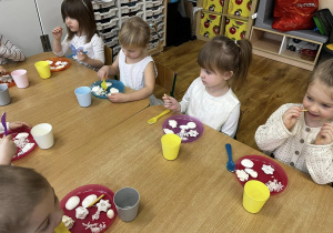 Zdjęcie grupowe dzieci siedzących przy stoliku podczas degustacji.