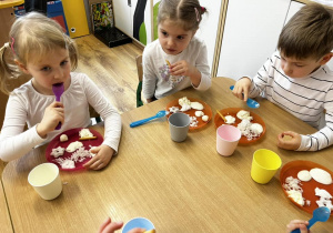 Zdjęcie grupowe dzieci siedzących przy stoliku podczas degustacji.