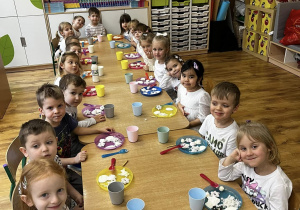 Zdjęcie grupowe dzieci siedzących przy stoliku podczas degustacji.