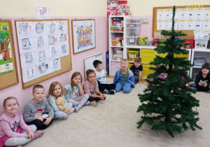 Dzieci czekają na swoją kolej w ubieraniu choinki.