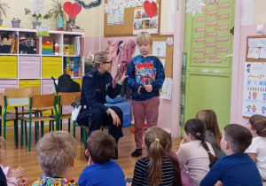 Chłopczyk wykonuje polecenia pani policjantki.