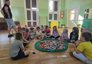 Dzieci uważnie słuchają nauczyciela, jak zbudować statek