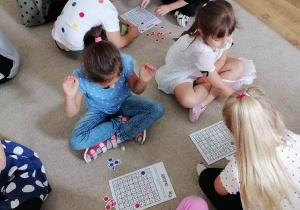 Dzieci grają w gry planszowe i matematyczne z wykorzystaniem plansz pełnych kropek.