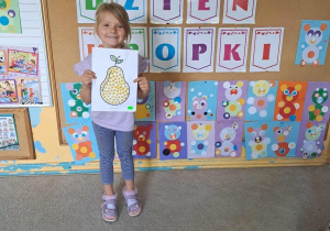 Aniela prezentuje swój obrazek gruszki.