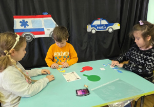 Dzieci układają znaki drogowe z obrazków.