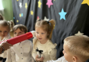 Akt pasowania: ołówek przy ramieniu dziecka.