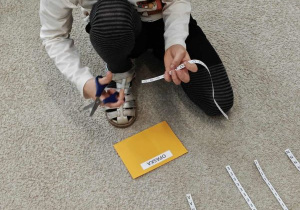 Dziewczynka odcina literę.